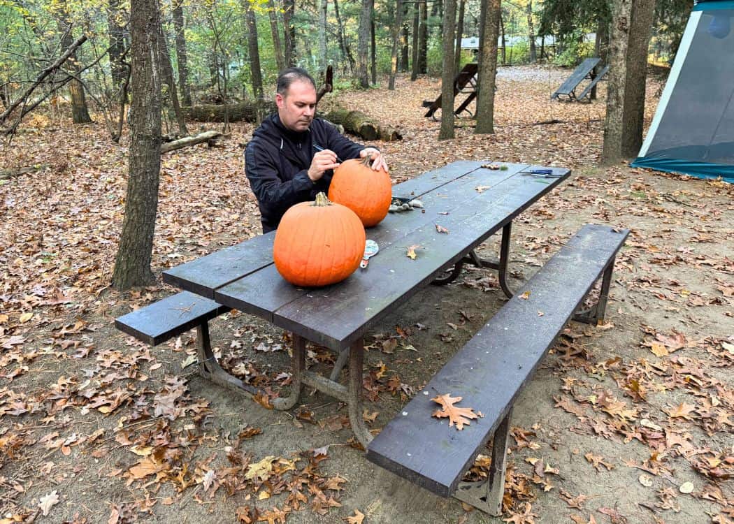 Ontario Parks Halloween - John drawing faces on pumpkins
