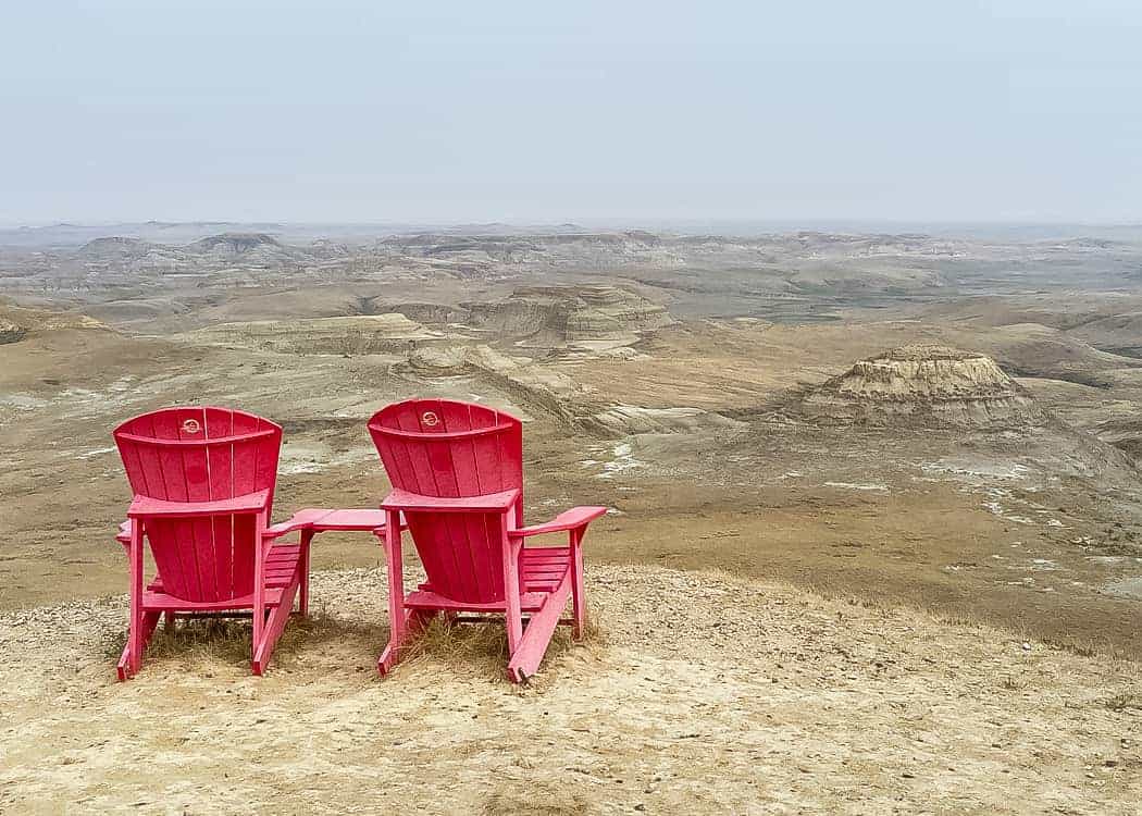 Grasslands NP - Parks Canada Red Chairs facing Badlands