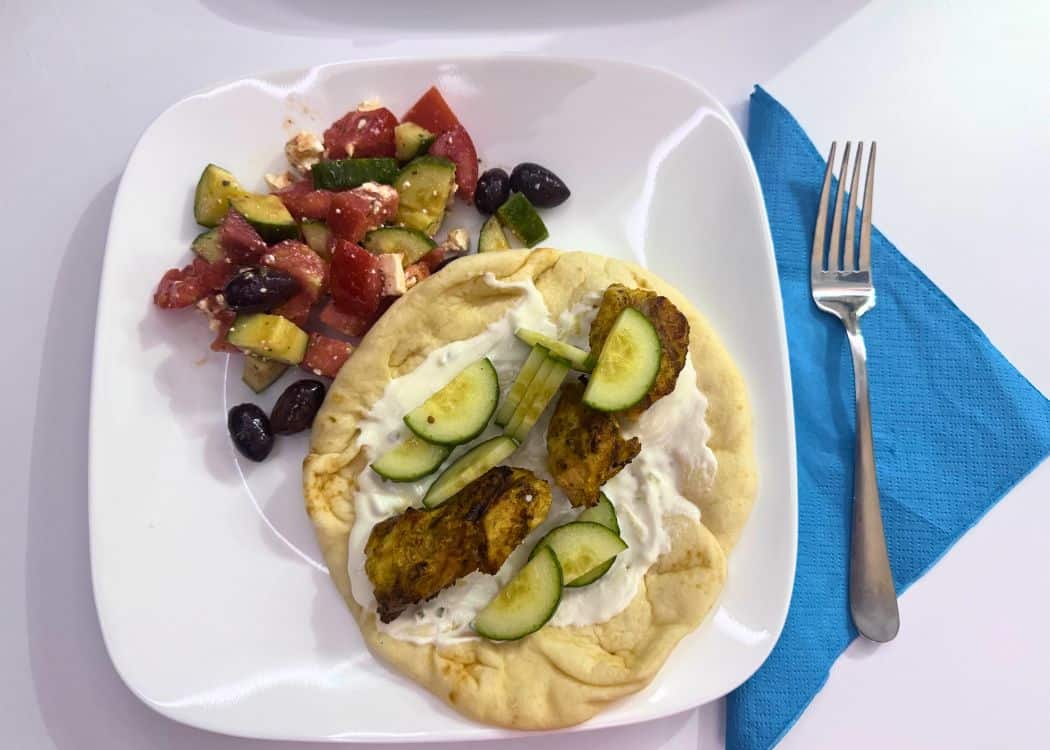 What We Eat While Camping - Greek chicken kebab and Greek salad on a plate